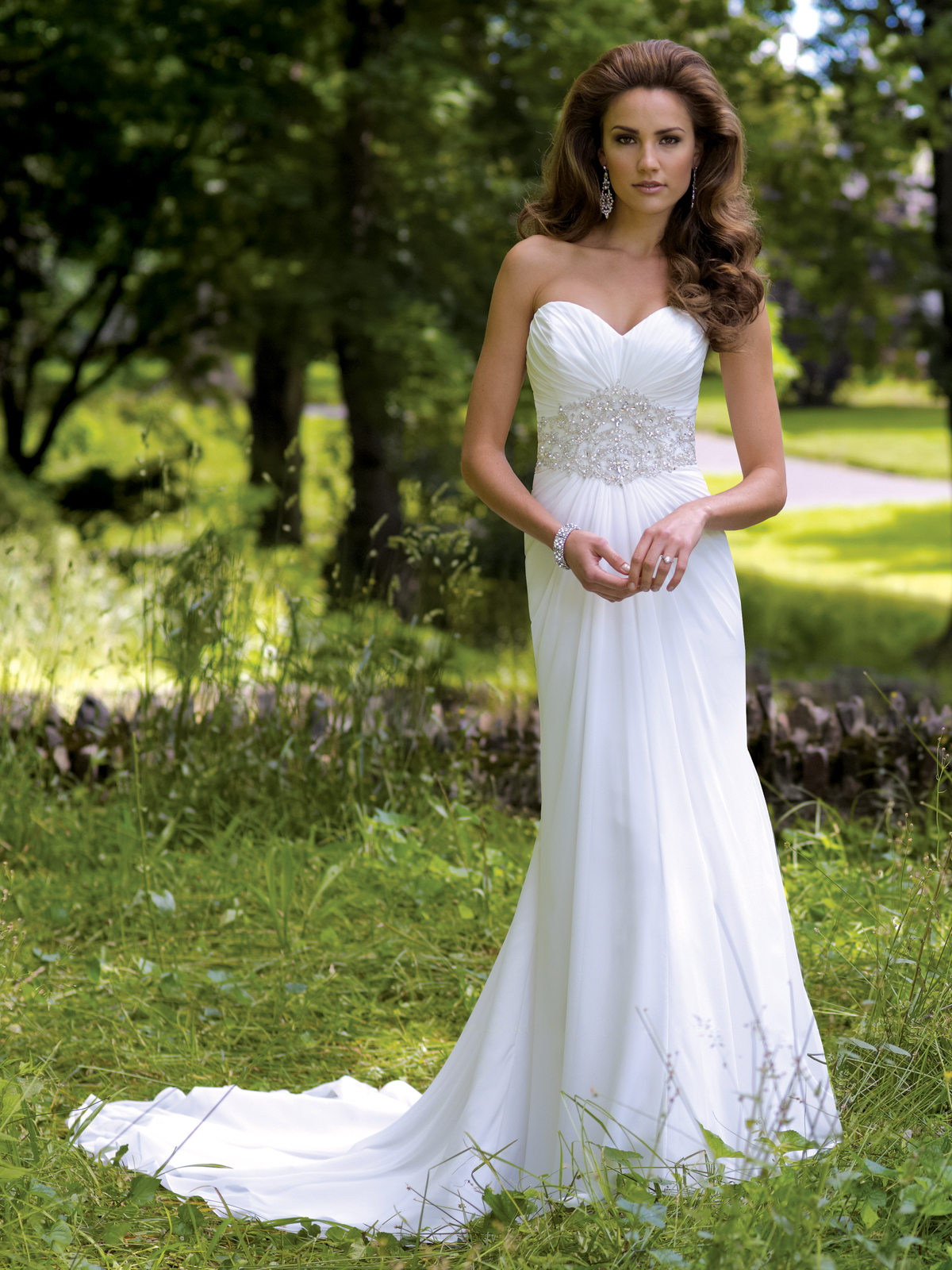 A bride in a casual wedding dress walking down the beach